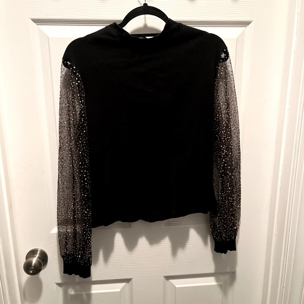 Black top with sheer sequin arms.